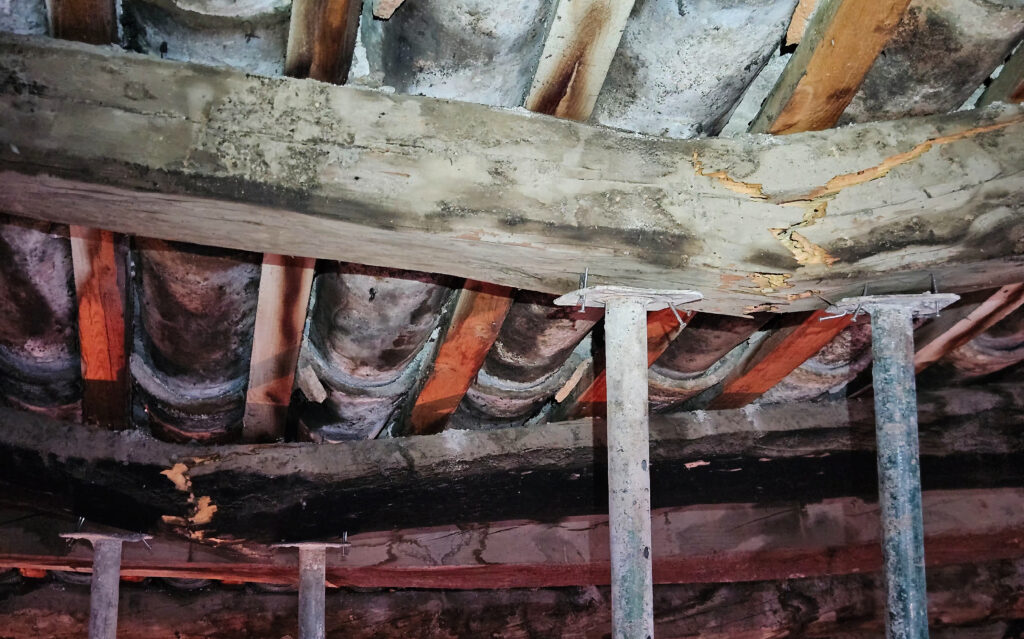 En la imagen, dos vigas de madera han colapsado en una cubierta...