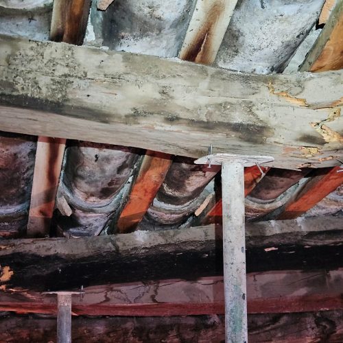 En la imagen, dos vigas de madera han colapsado en una cubierta...