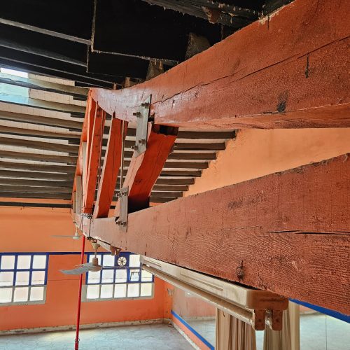 En la imagen, una cercha de madera objeto de una diagnosis de patologías, nos muestra claramente la deformación de este elemento estructural…
