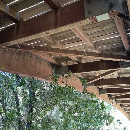 En la imagen, la cara inferior de un puente de madera permite observar la lógica constructiva...